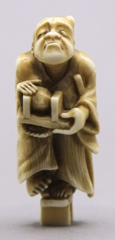 NETSUKE A Man who is upset, because a Stone got stuck in his Sandal